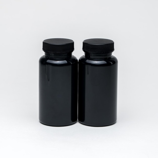 Foto frascos de comprimidos de plástico preto sobre um fundo branco. isolado