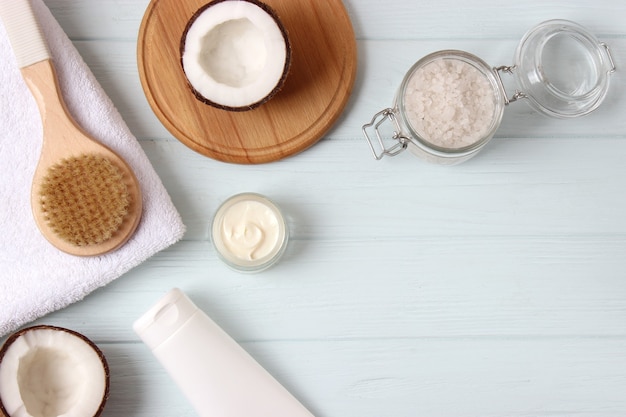 Frascos de cosméticos e coco na mesa, close-up e lugar para texto