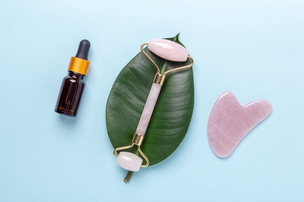 Frascos de cosméticos, soro facial, rolo de massagem facial e massageador gua sha