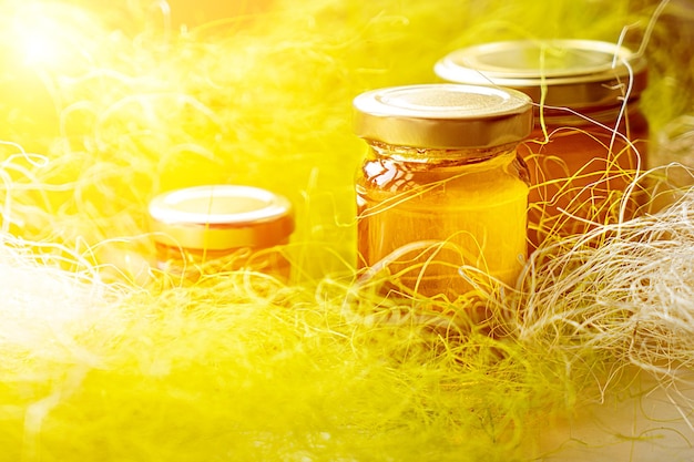 Frascos de mel em um fundo amarelo com a palavra mel no topo