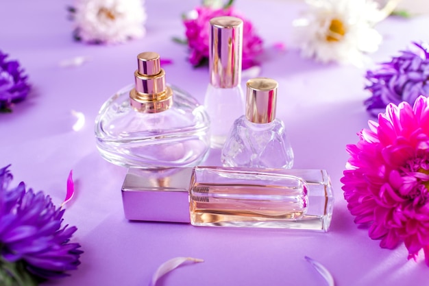 Frascos de perfume com flores roxas e brancas