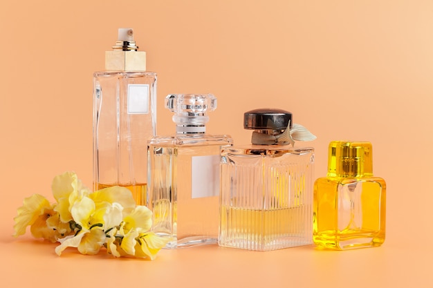 Frascos de perfume com pétalas de flores em bege