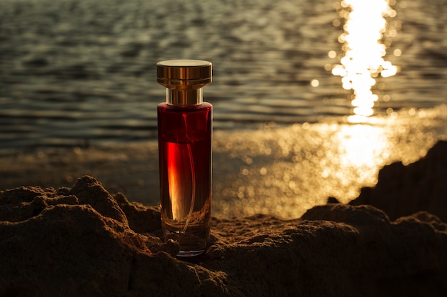 Frascos de perfume transparente contra o pôr do sol da noite. conceito de beleza masculina.