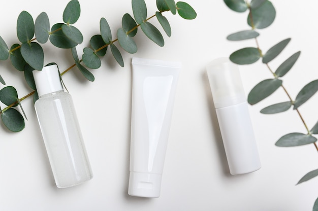 Foto frascos de produtos cosméticos na vista superior de fundo branco. creme facial, máscara.