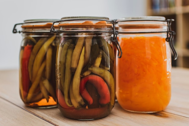 Frascos de vidro com pimentas e legumes lacofermentados marinados