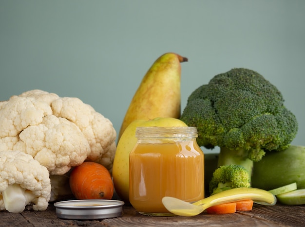 Frascos de vidro com purê de comida infantil de vegetais naturais na mesa de madeira