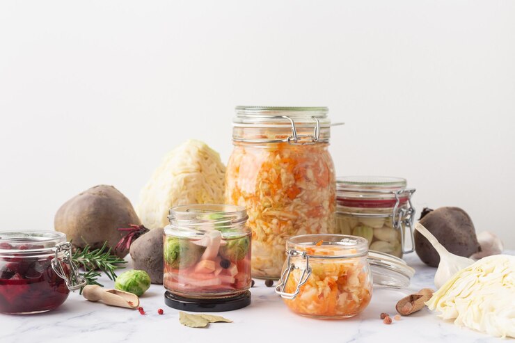 Frascos de vidro com vários vegetais em conserva e ingredientes em uma foto de alta qualidade de fundo de mármore