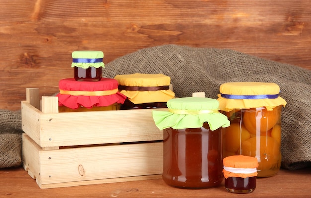 Frascos con fruta enlatada sobre fondo de madera