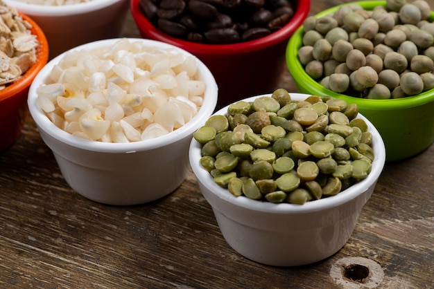 Frascos con granos de frijoles en una mesa de madera