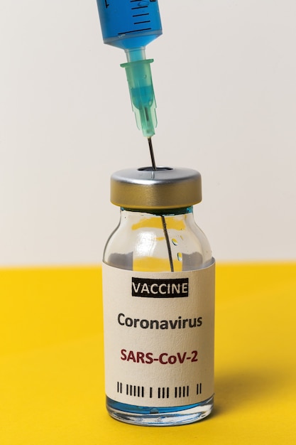 Frascos para injectáveis de vidro transparente com vacina teste COVID-19, com seringas. Foco selecionado.