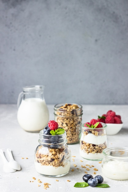 Frascos con parfait de granola, bayas y yogurt.