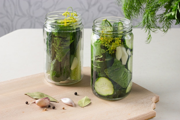 Foto frascos con pepinos encurtidos con ajo, rábano picante y pimiento