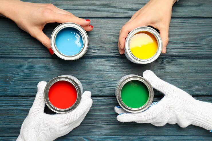 Frascos con pinturas y manos en la vista superior de fondo de madera