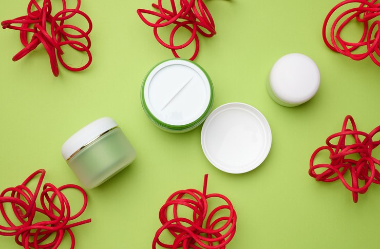 Foto frascos de plástico blanco vacíos para cosméticos sobre un fondo verde. embalaje para crema, gel, suero, publicidad y promoción de productos, maqueta.