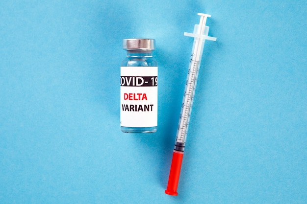 Frascos de vacuna covid - variante 19 delta, frascos de medicina e inyección de jeringa aislado en azul. Coronavirus DELTA 2019-ncov.