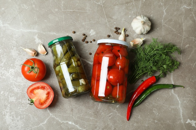 Frascos con verduras en escabeche e ingredientes en gris