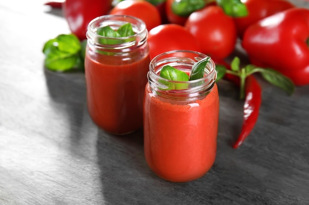 Frascos de vidrio con batido de verduras en mesa de madera