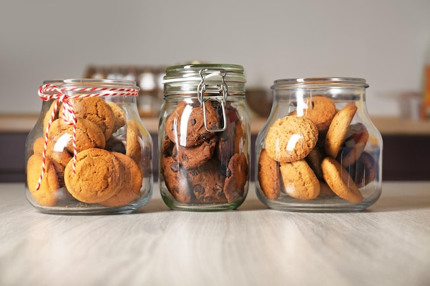 Frascos de vidrio con deliciosas galletas de avena en mesa de madera