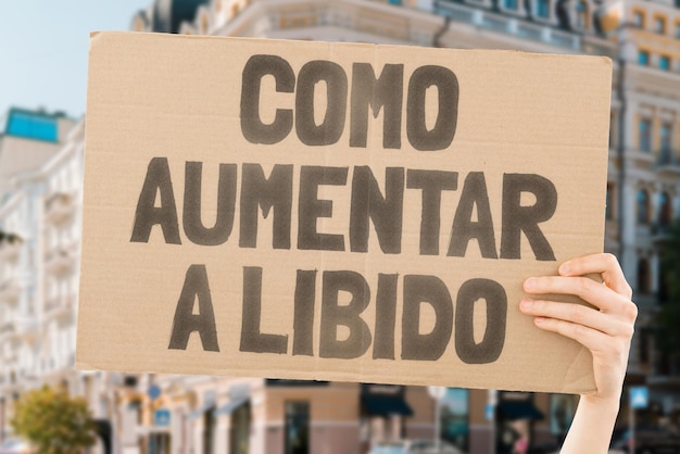 La frase Cómo aumentar la libido está en una pancarta en las manos de los hombres con un fondo borroso Deseo Placer Íntimo Intimidad Relación Sexo Vida privada Amor Dormitorio Salud sexual