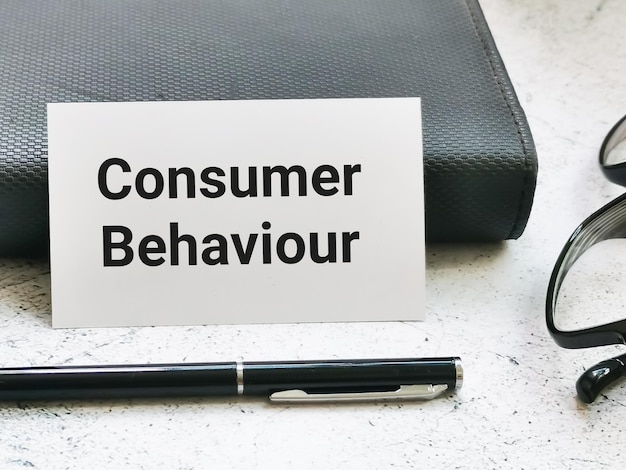 Foto frase del comportamiento del consumidor en una tarjeta blanca con un bolígrafo.