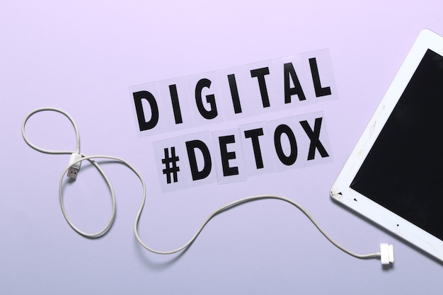 Foto frase detox digital y tableta craced. fondo morado, hashtag, vista superior.