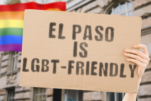 La frase "El Paso es LGBT-Friendly" en una pancarta en la mano de los hombres con una bandera LGBT borrosa en el fondo. Relaciones humanas. diferente. Diverso. libertad. Sexualidad. Problemas sociales. Sociedad