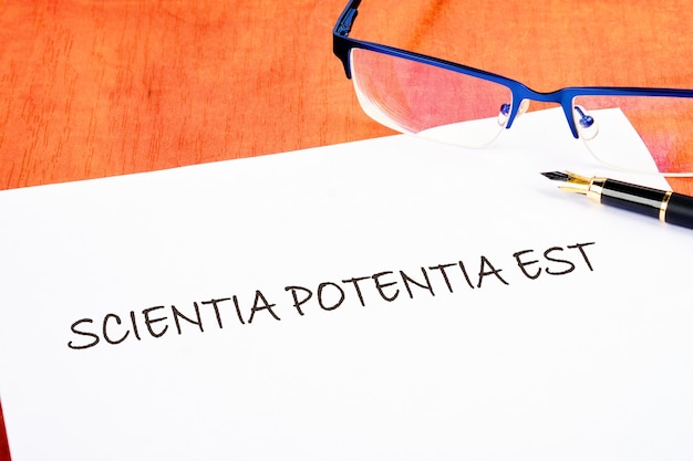 la frase Scientia Potentia Est El conocimiento es poder escrito en latín en una pieza blanca