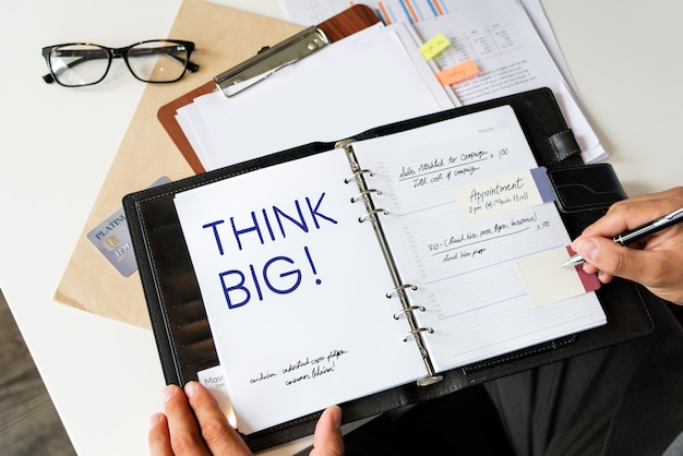 Frase Think big escrita en un cuaderno