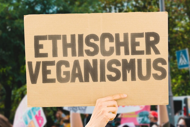 La frase Veganismo ético está en una pancarta en la mano de los hombres Nutrición saludable Sin carne Creencia filosófica Libre de crueldad Alimentos vegetales Protección animal Animales