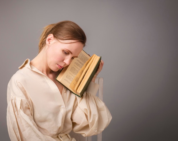 Frau 40 Jahre alt mit einem Buch auf hellem Hintergrund