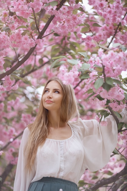 Frau am blühenden Sakura-Baum auf Natur