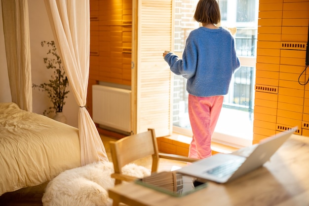 Frau am Fenster zu Hause