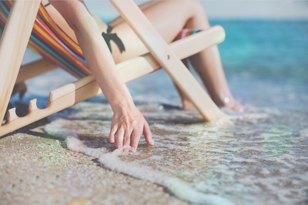 Frau am schönen Strand entspannt auf dem Stuhl