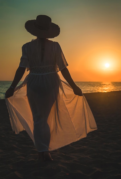 Frau am Strand bei Sonnenuntergang. Selektiver Fokus.