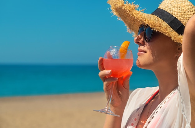 Frau am Strand, die einen Cocktail in ihren Händen hält. Selektiver Fokus. Getränk.