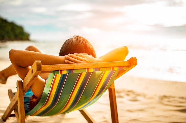 Foto frau am strand entspannen, blick aufs meer. platz kopieren.