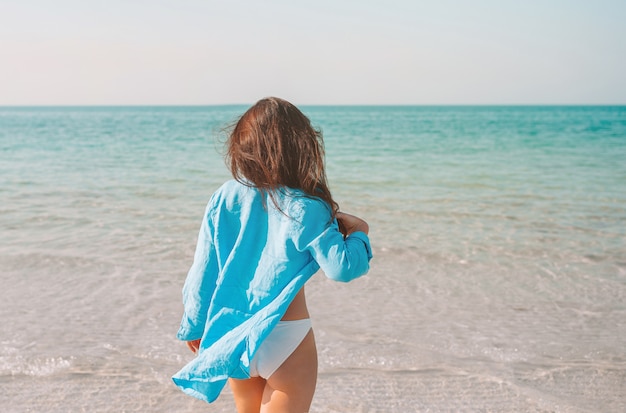 Frau am Strand genießt Sommerferien mit Blick auf das Meer