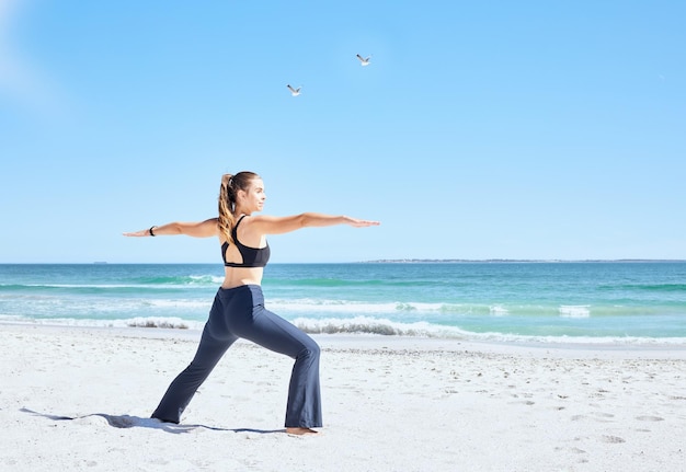 Frau am Strand Yoga und Pilates-Übungen am Meer in der Sommersonne für Gesundheit, Fitness, Flexibilität und Vitalität Zen-Stretching-Training auf Meeressand und Selbstpflegetraining für das Gleichgewicht der psychischen Gesundheit