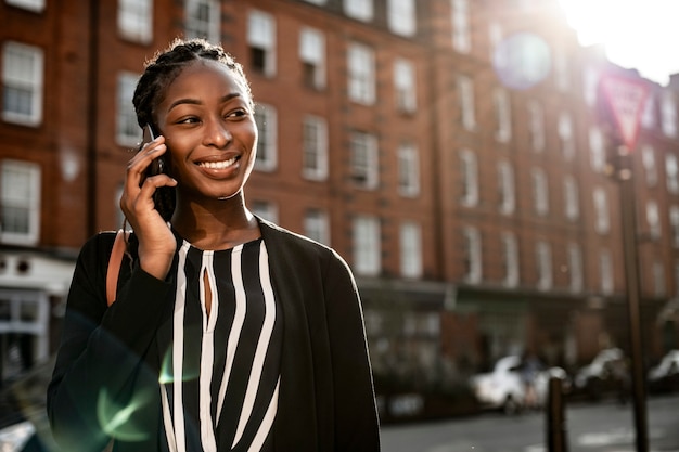 Frau am Telefon beim Spaziergang durch die Stadt