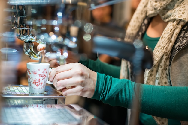 Frau an der Bar bereitet Espresso zu