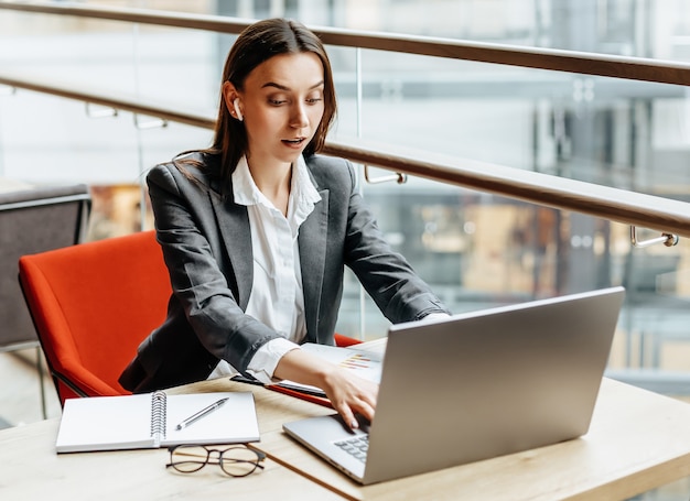 Frau arbeitet an einem Laptop am Arbeitsplatz