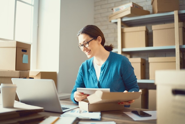 Frau arbeitet im Lager für Online-Shop.