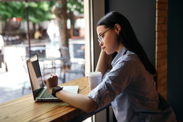 Frau arbeitet mit Laptop im Café