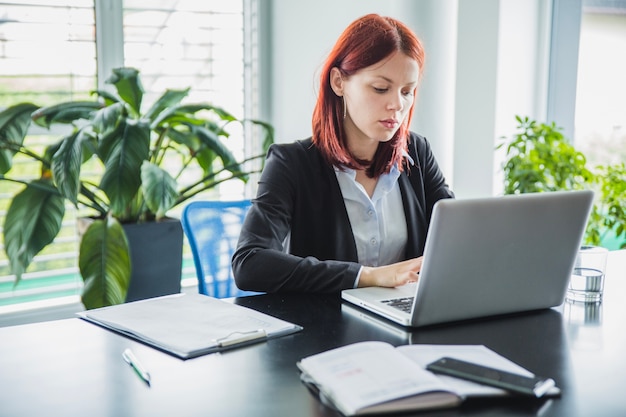 Foto frau arbeitet mit laptop im modernen büro