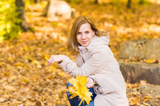 Frau auf Blättern im Herbstpark