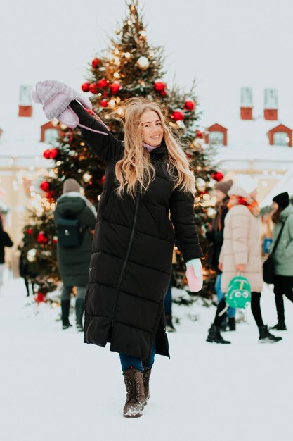 Frau auf dem Hintergrund eines Weihnachtsbaumes im Winter