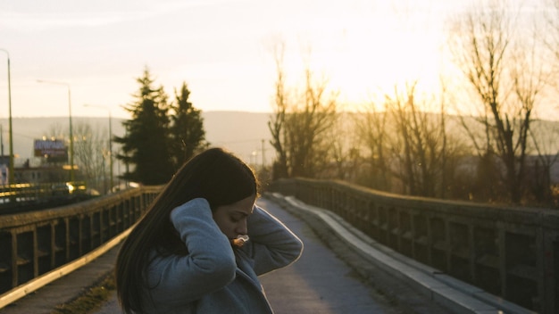 Foto frau auf der brücke bei sonnenuntergang