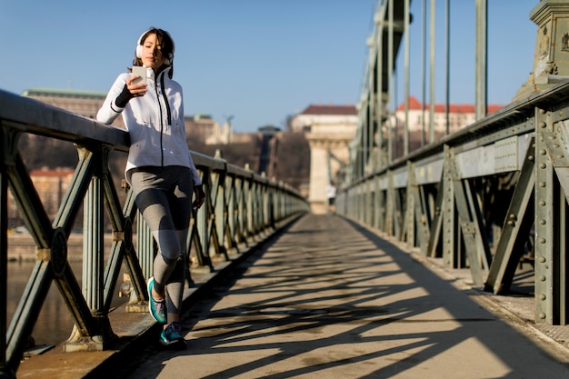 Frau auf der Brücke, die eine Pause nach der Übung macht