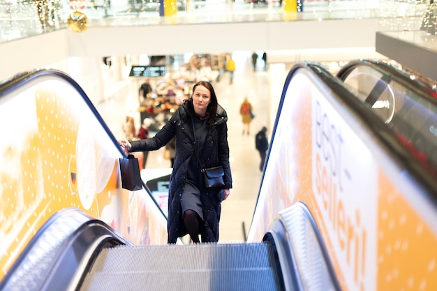 Frau auf der Rolltreppe im Einkaufszentrum