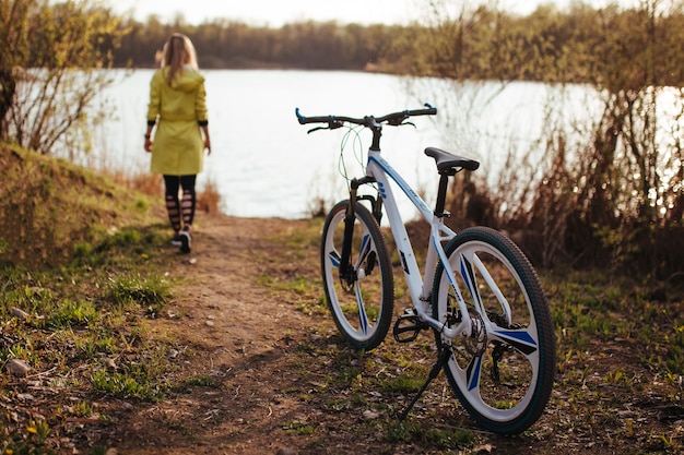 Frau auf einem Fahrrad in einem gelben Regenmantel im Wald